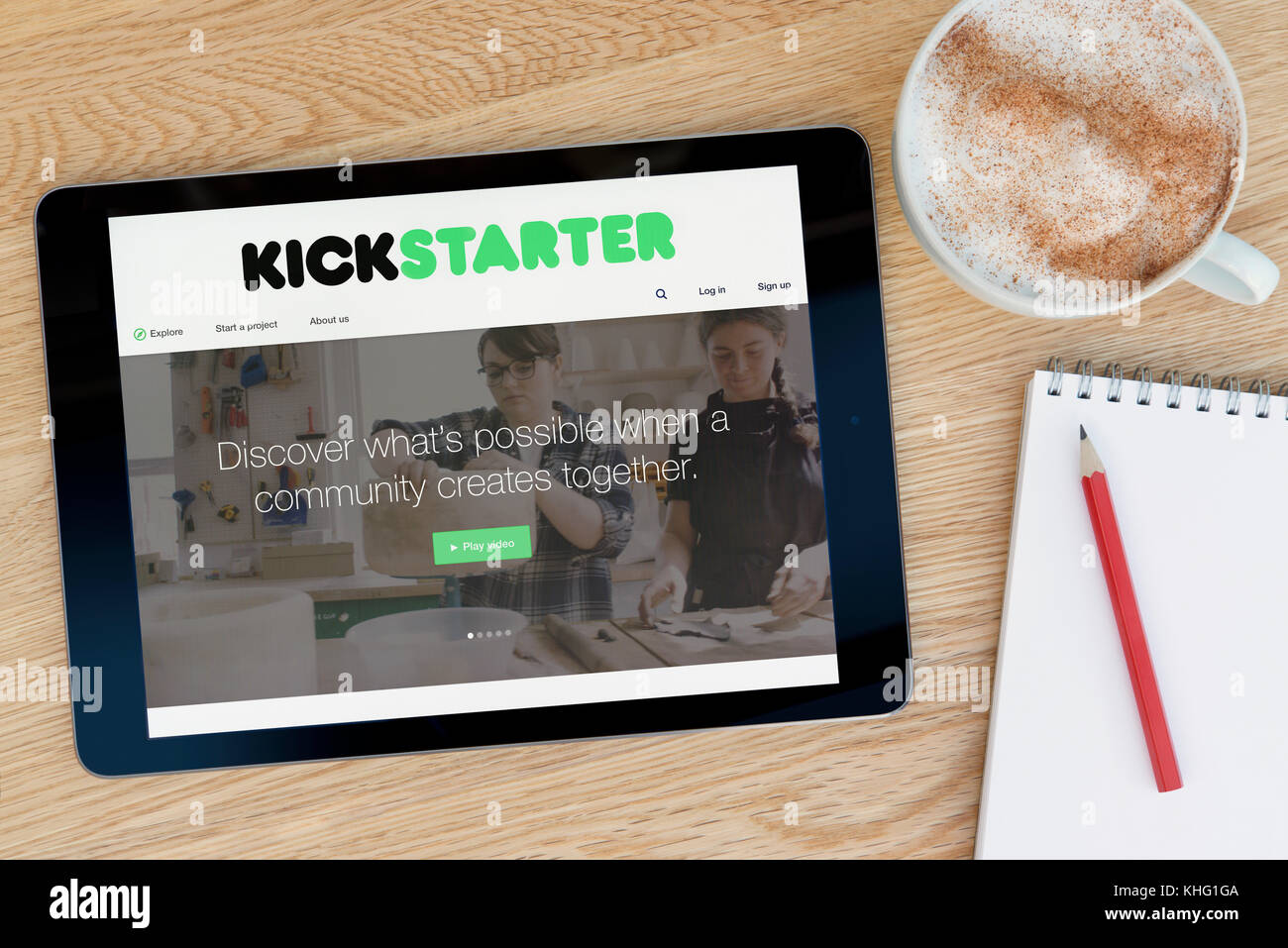 Il sito Kickstarter su un iPad dispositivo tablet pc che si appoggia su una tavola di legno accanto a un blocco note e matita e una tazza di caffè (editoriale solo) Foto Stock