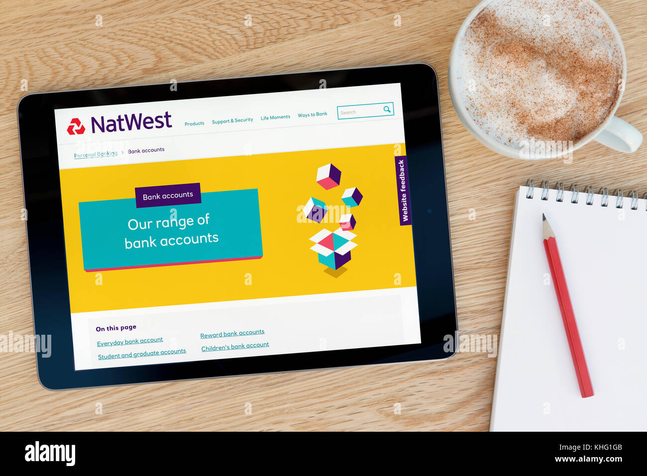 La Natwest funzionalità del sito su un iPad dispositivo tablet pc che si appoggia su una tavola di legno accanto a un blocco note e matita e una tazza di caffè (editoriale solo) Foto Stock