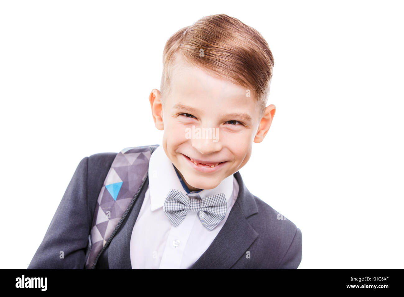 Ritratto di felice scolaro con zaino isolati su sfondo bianco. Sorridente schoolchild primario in tuta Foto Stock