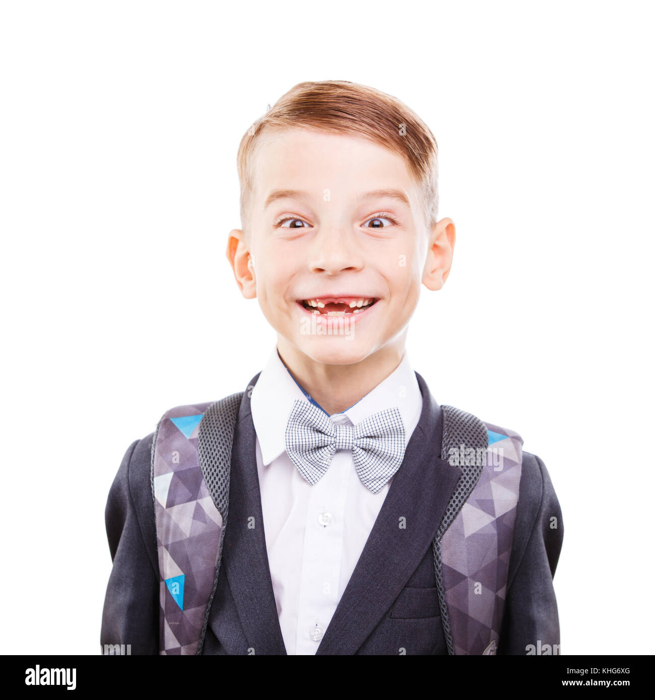 Giovani carini scuola primaria studente ingannare intorno a. Giovani carino schoolboy mostra teethless sorriso isolati su sfondo bianco Foto Stock