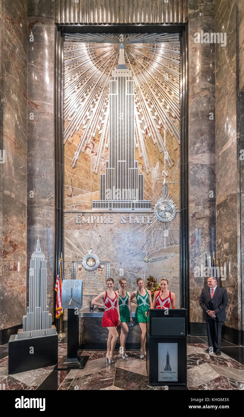 New York, Stati Uniti d'America. Xvi Nov, 2017. Radio City Music Hall Rocketttes parlare prima di accendere le luci dell'Empire State Building in rosso e in verde nella celebrazione della serata di apertura del loro Christmas Spectacular Show. A destra è Giuseppe 'Joe' Bellina, General Manager dell'Empire State Building, Credito: Enrique Shore/Alamy Live News Foto Stock