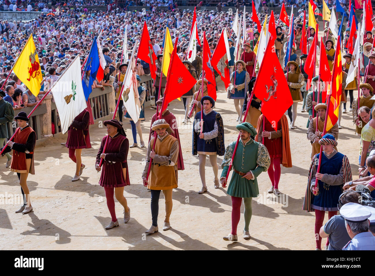 Gli uomini che trasportano una storica bandiera durante il Corteo Storico sfilata prima del Palio di Siena corsa di cavalli, Siena, Toscana, Italia Foto Stock