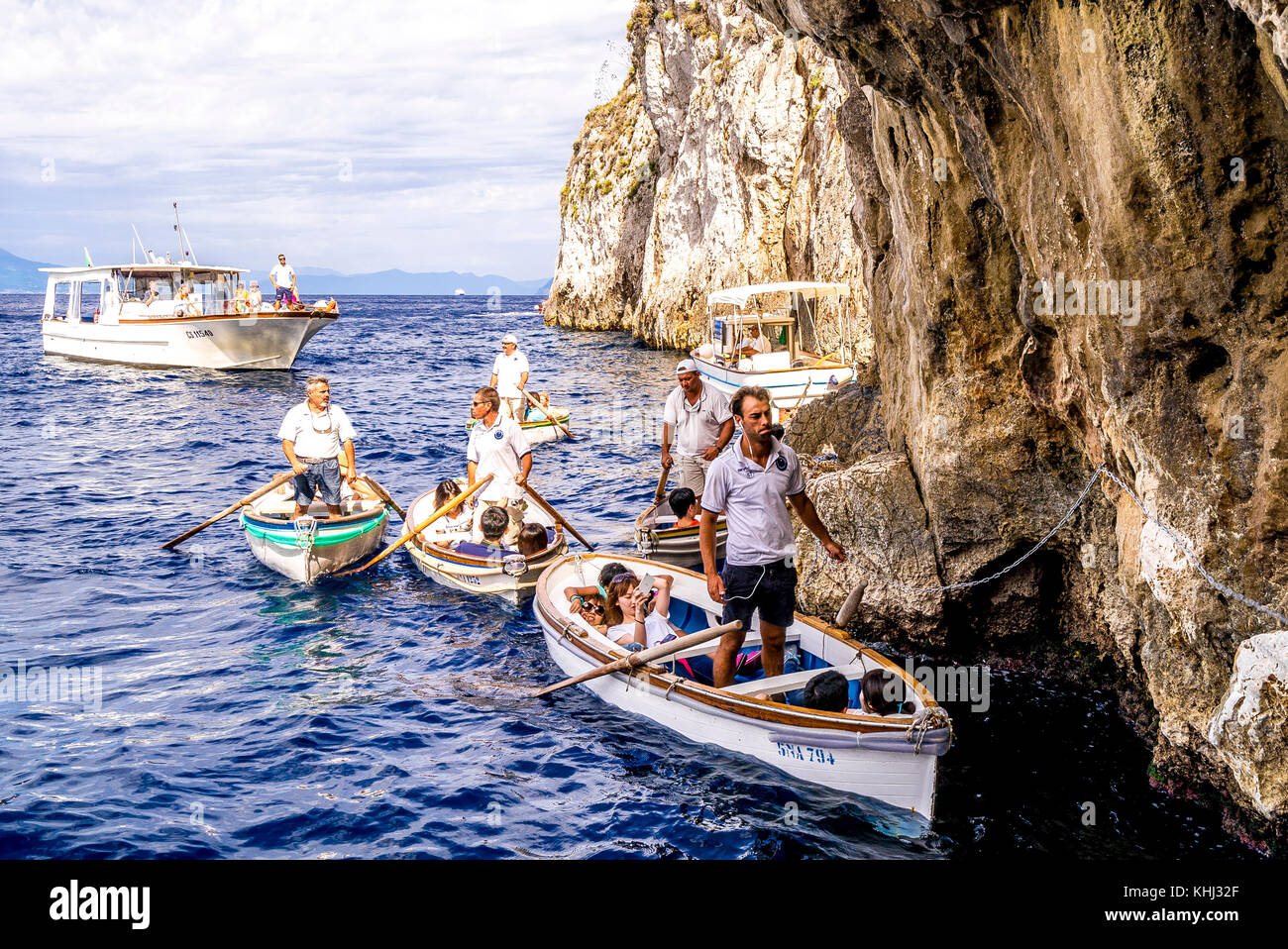 Una fila di turisti attende in una piccola barca per entrare nella famosa Grotta Azzurra sull'isola di Capri in Italia Foto Stock