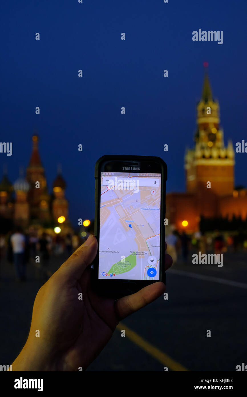 Mano maschile che regge uno smartphone con l'app Google Maps in esecuzione Foto Stock