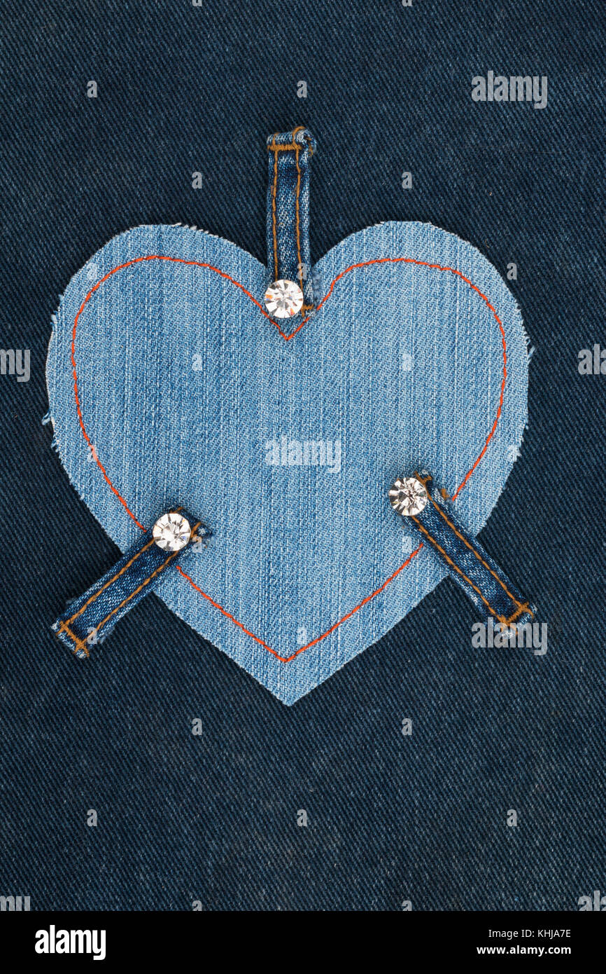 Cornice fatta di jeans a forma di cuore, giace su un tessuto denim. Spazio per il testo. Vista da sopra Foto Stock