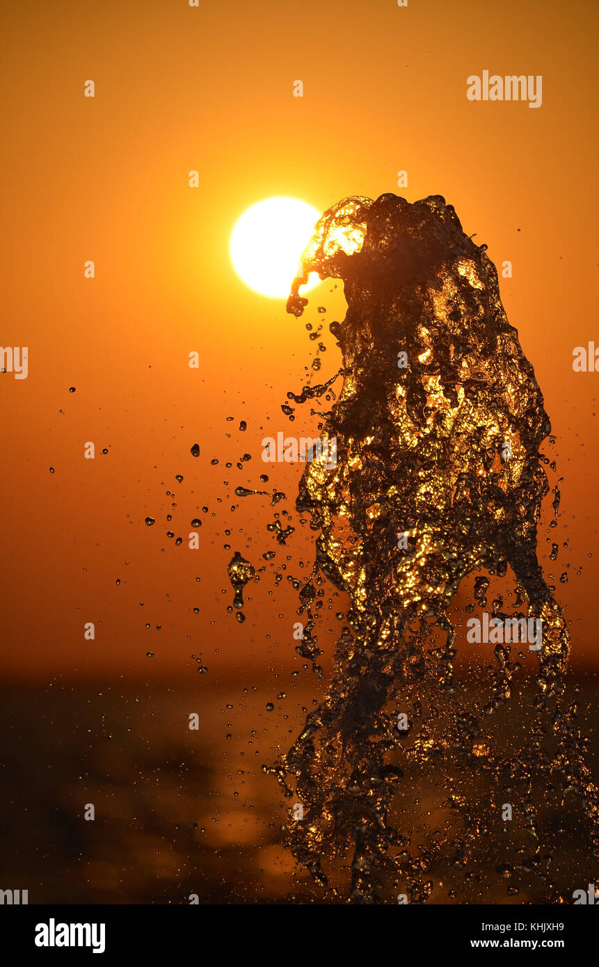 Acqua Splash isolato sul tramonto colori dello sfondo. Foto Stock