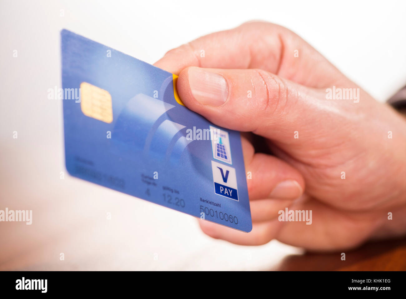 Primo piano di una mano con girocard di Postbank e logo V Pay Foto Stock