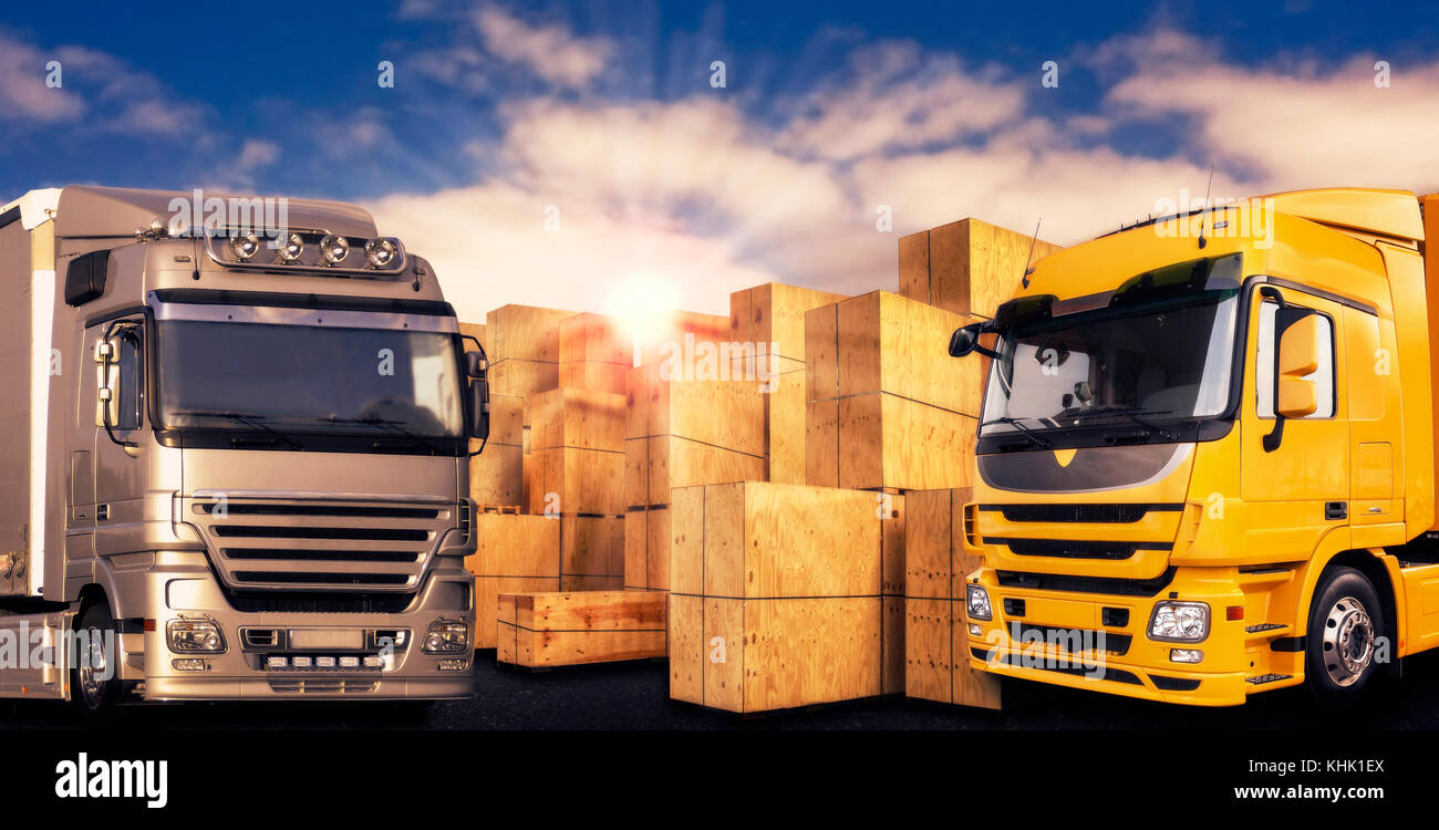 Due moderni camion e molte scatole di trasporto nella parte anteriore del cielo della sera Foto Stock