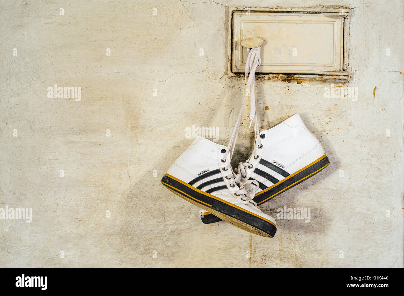 Minsk, Bielorussia - 29 settembre 2017: bianco adidas sneakers appendere su lacci e a secco su una stufa russa, close-up Foto Stock