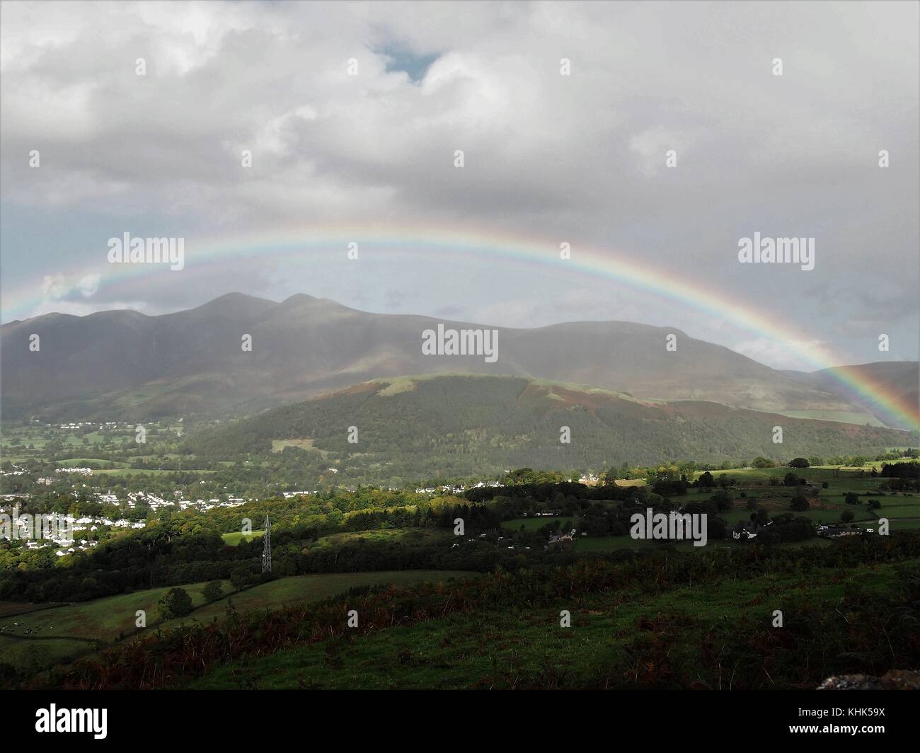 Rainbow framing skiddaw da walla roccioso, parco nazionale del distretto dei laghi, cumbria, Regno Unito Foto Stock