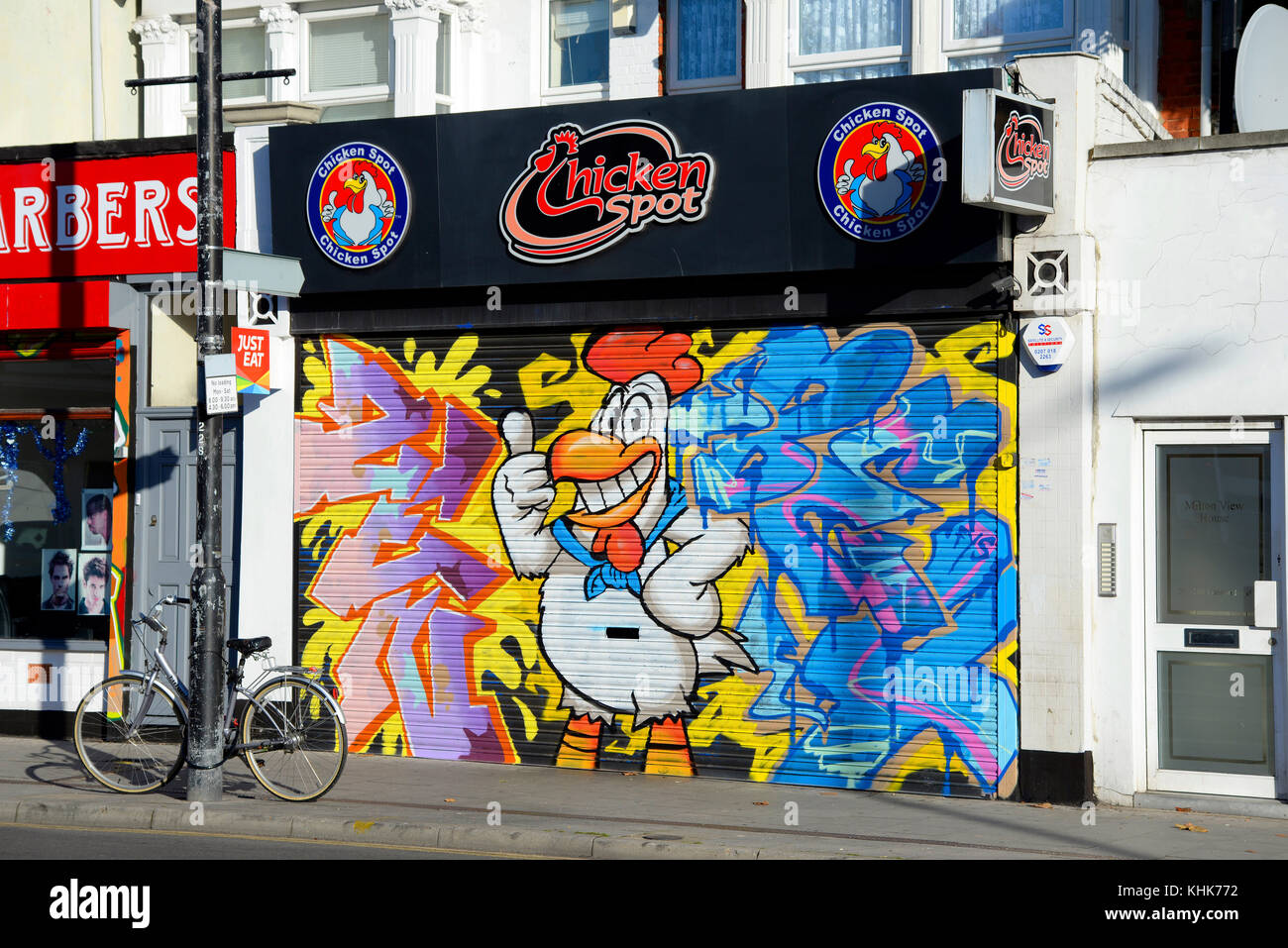 Spot di pollo fast food take away con grande arte dei graffiti street art artwork spruzzata sull'otturatore chiuso. Foto Stock