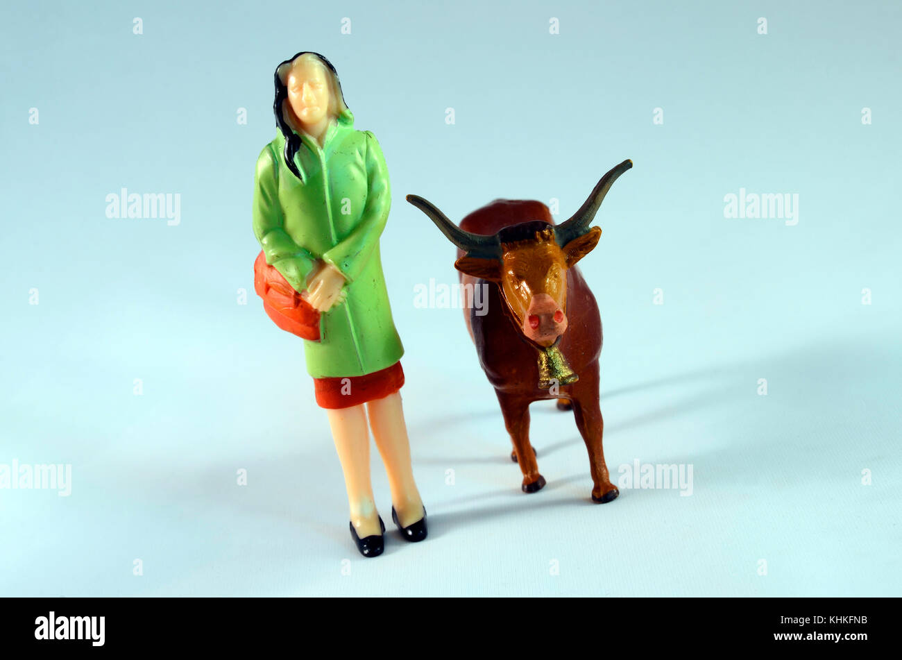 Donna di plastica con la sacca e la mucca : caratteri miniaturizzati Foto Stock