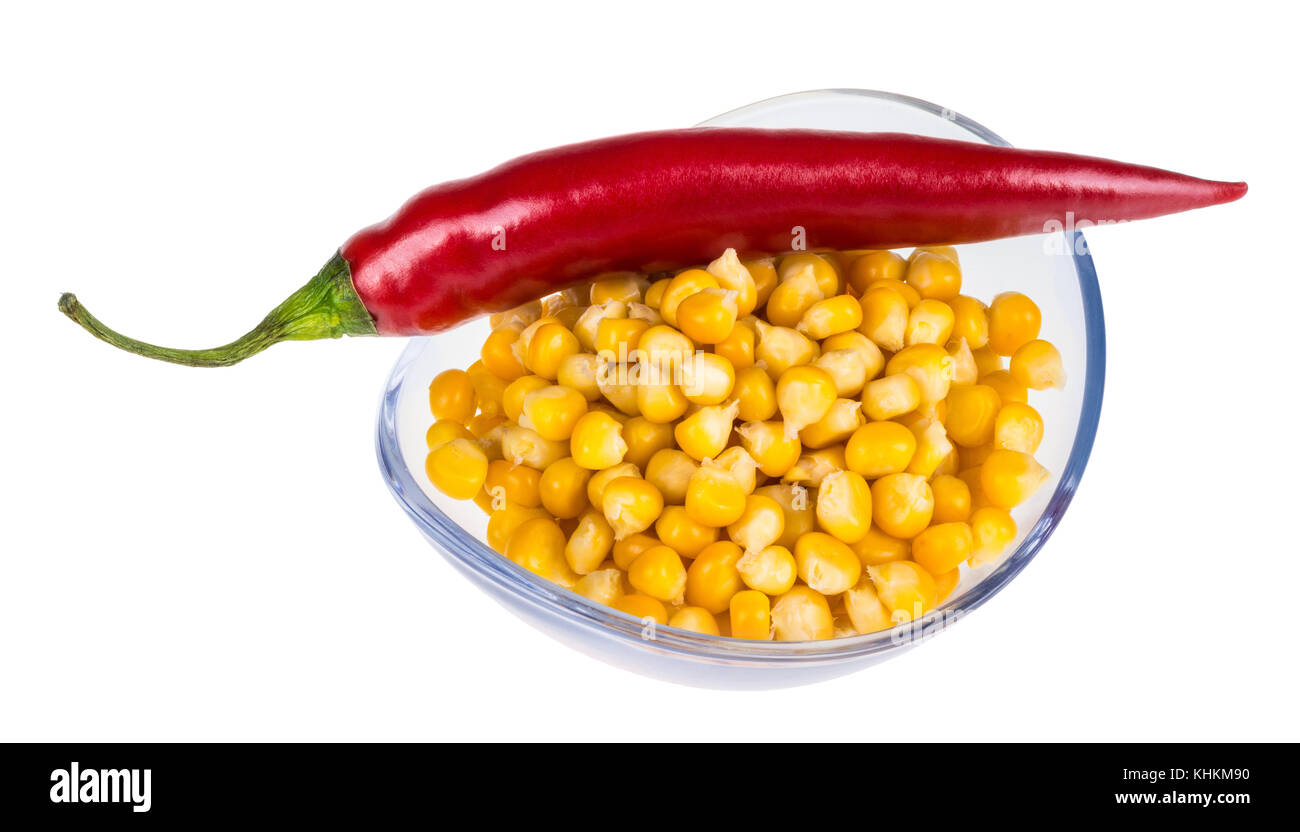 Ciotola con il mais e il peperoncino. mais giallo e rosso capsicum in recipiente di vetro isolato su sfondo bianco. Foto Stock