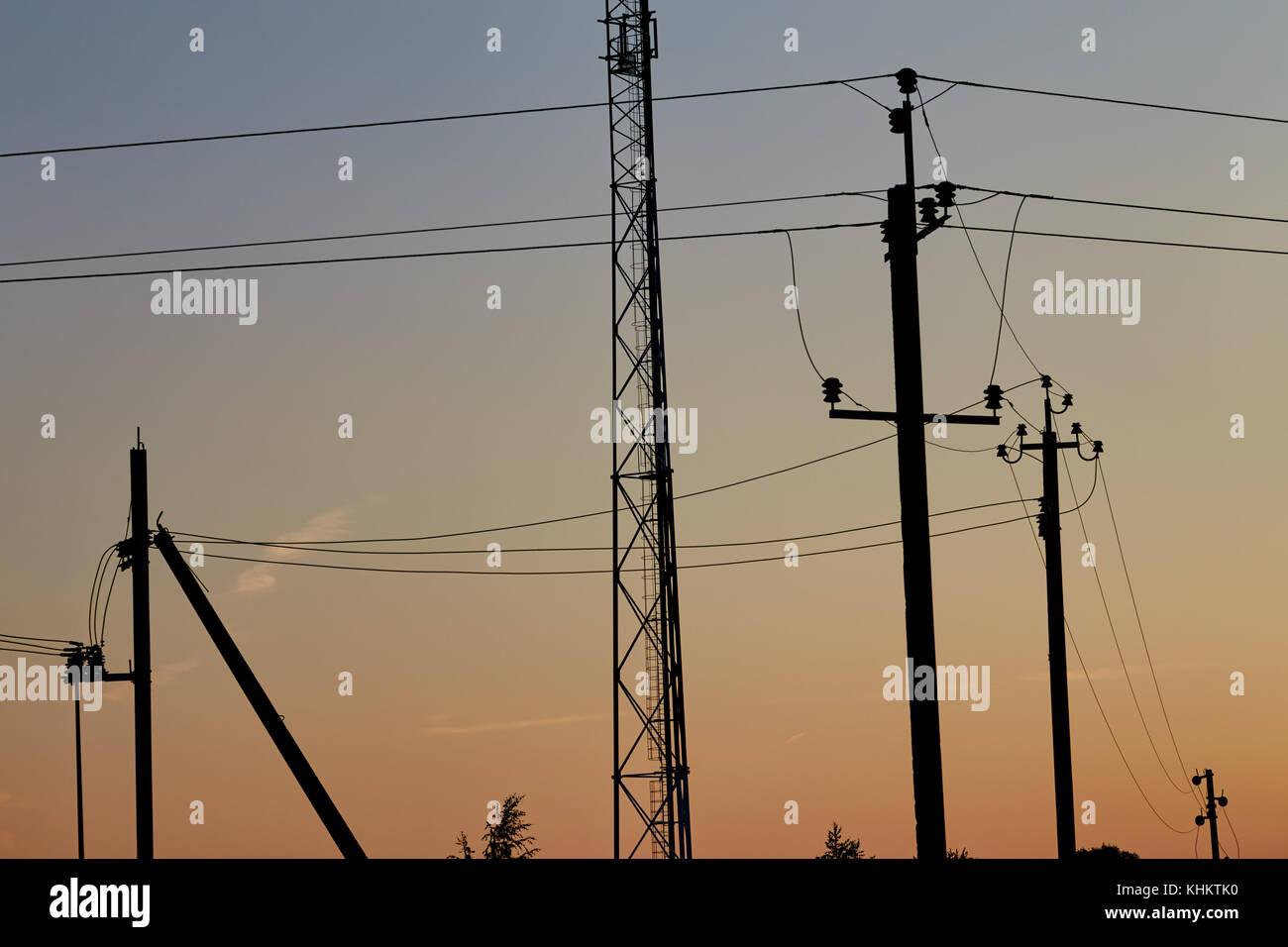Sagome di elettro-posti con i fili contro lo sfondo del cielo della sera Foto Stock