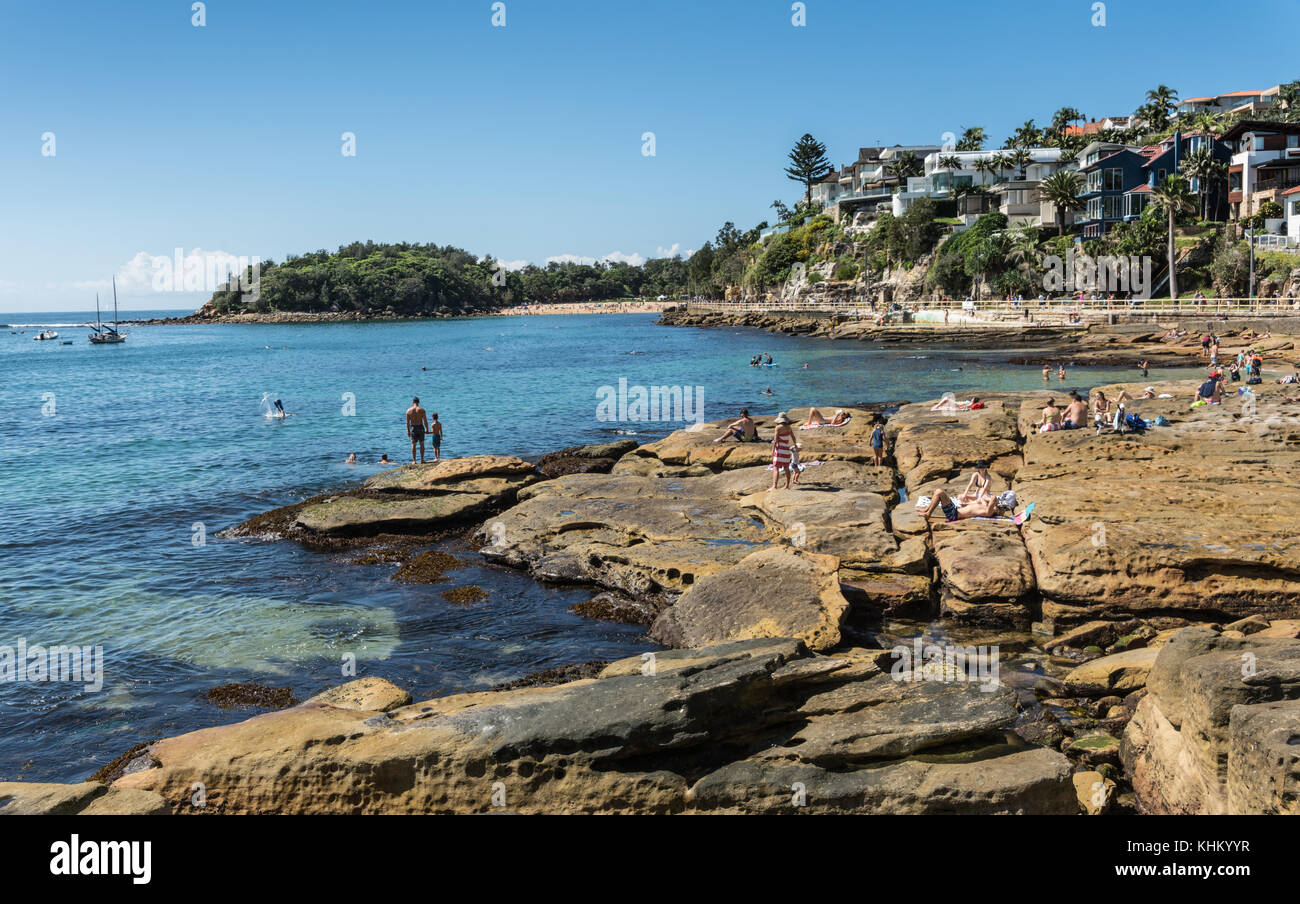 Sydney, Australia - 26 marzo 2017: rocciosa la parte sud della spiaggia di Manly con rocce e Mare di Tasman. persone sulle rocce e nell'acqua. condominiums un Foto Stock