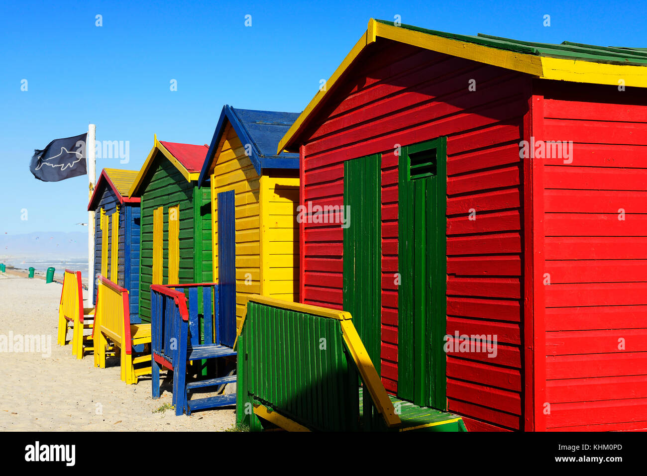 Colorati bungalow sulla spiaggia con bandiera di squalo, muizenberg false bay, Western Cape, Sud Africa Foto Stock
