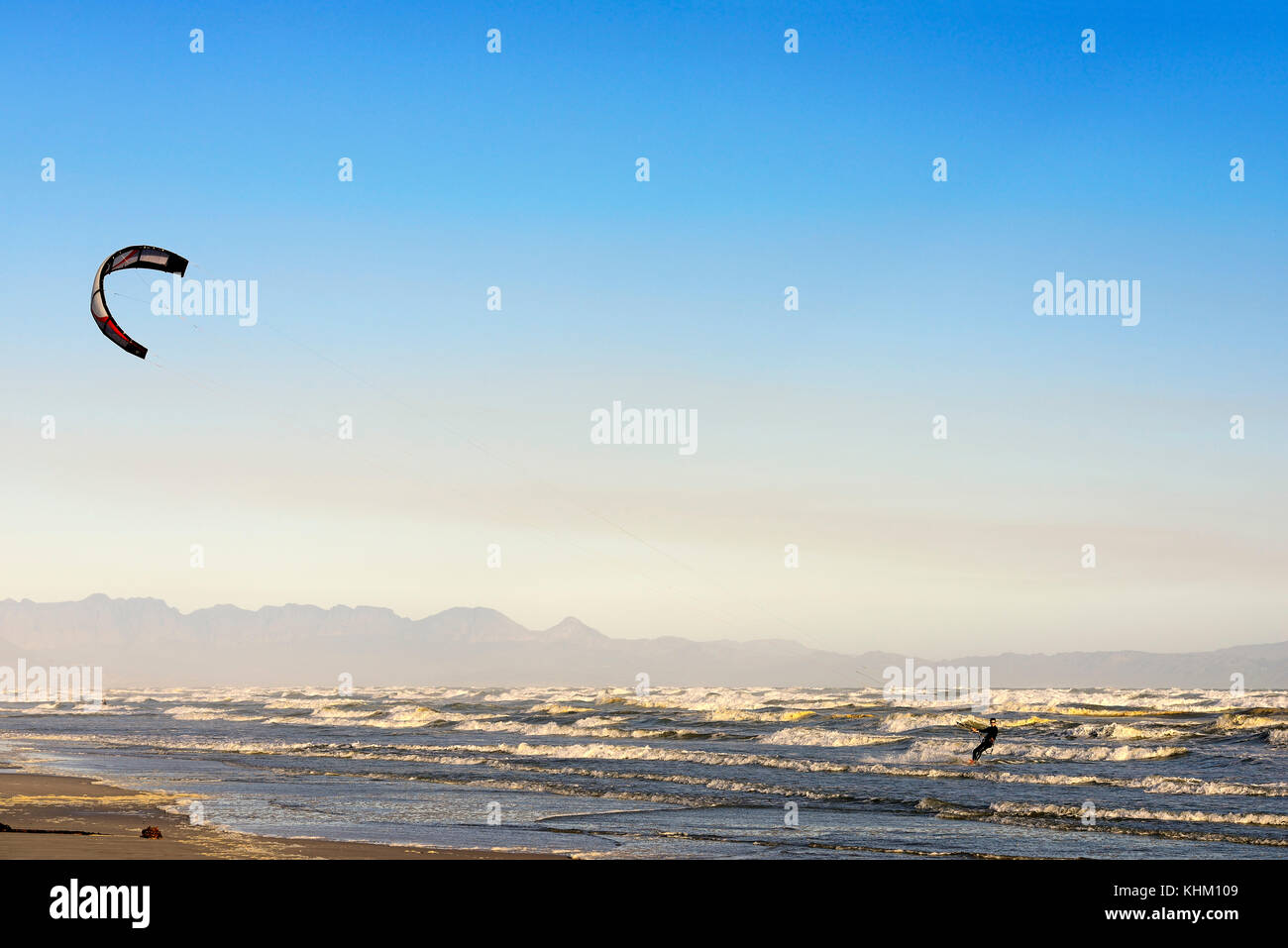 Kitesurfisti ad alte onde, vicino a muizenberg false bay, Western Cape, Sud Africa Foto Stock