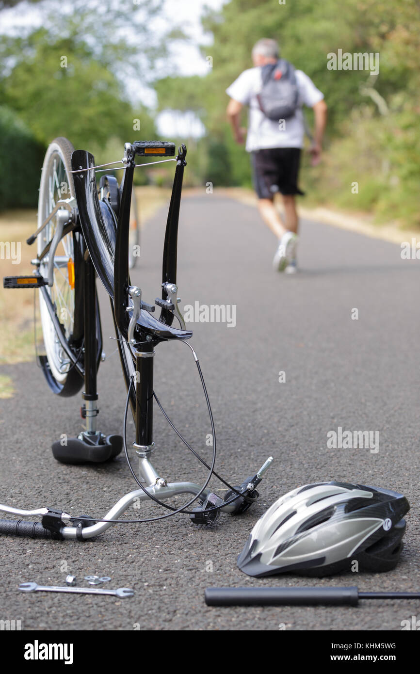 Ciclista lasciando la sua bicicletta distrutto Foto Stock