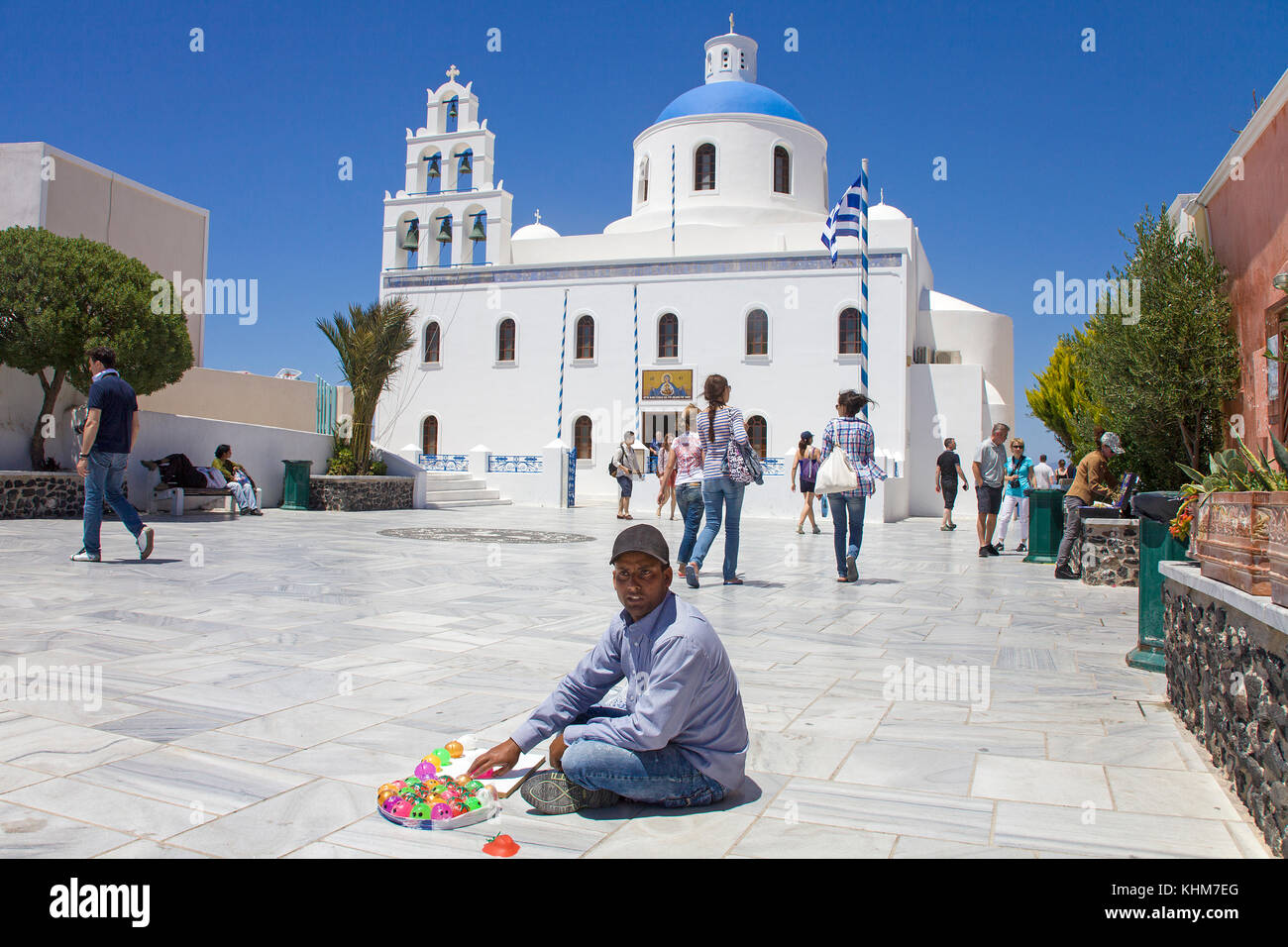 Venditore ambulante seduto alla chiesa panagia , chiesa ortodossa presso il villaggio di Oia, isola di Santorini, Cicladi, Egeo, Grecia Foto Stock