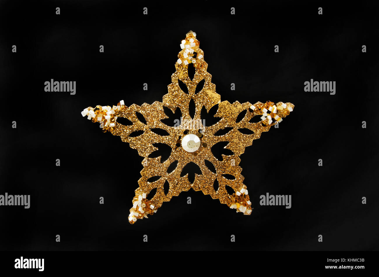 Oro glitter e jewelled star decorazione chistmas isolata contro il nero Foto Stock