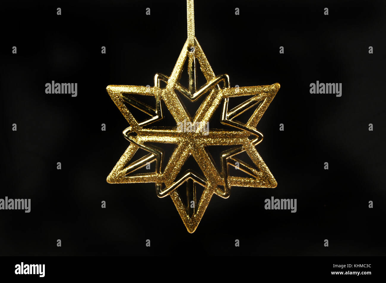 Oro glitter stella di Natale contro il nero Foto Stock