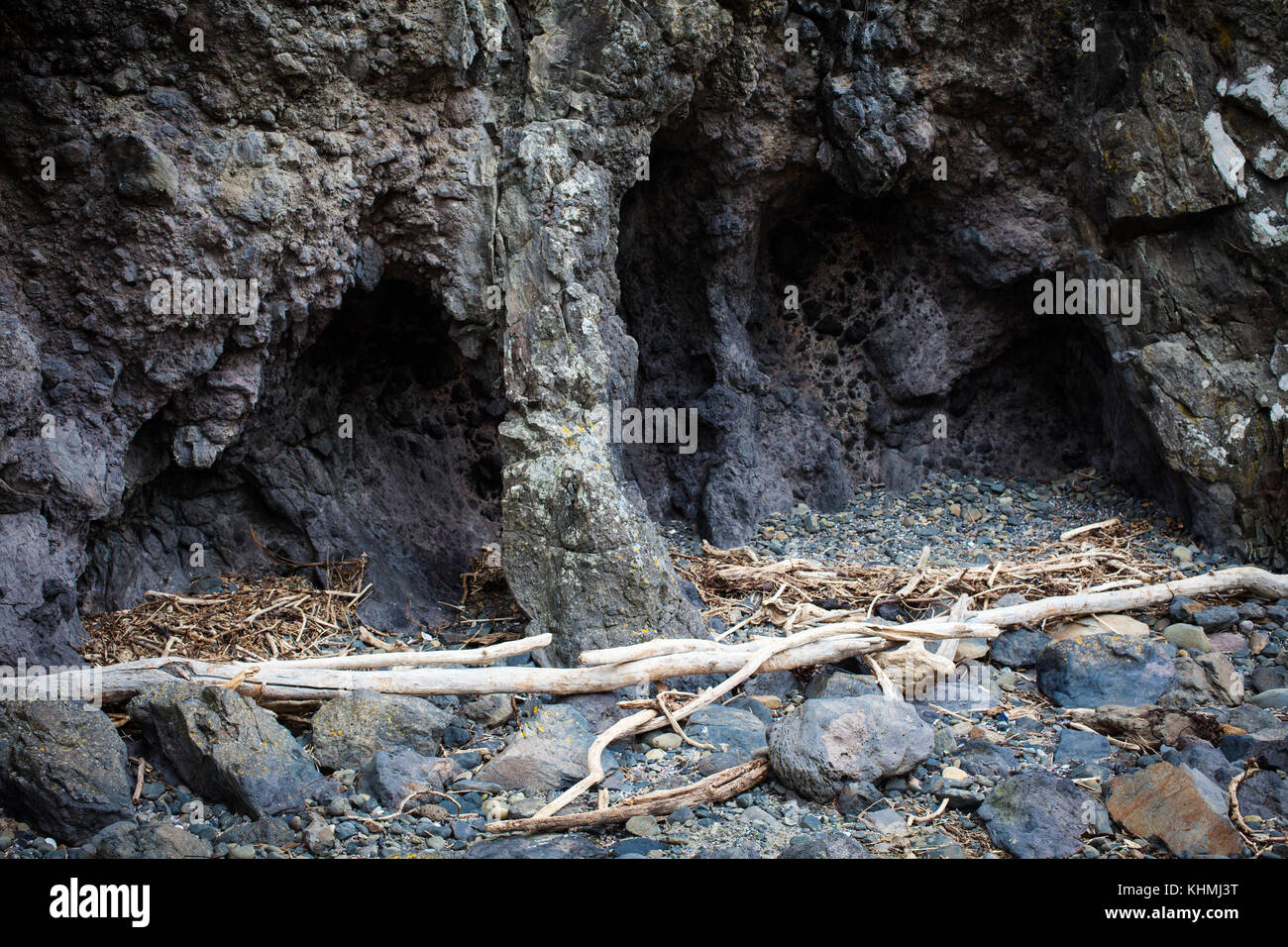 Attrazioni lungo la spiaggia in una baia isolata, Isola del Sud, Nuova Zelanda: grotte nel robusto, rocce vulcaniche. Foto Stock