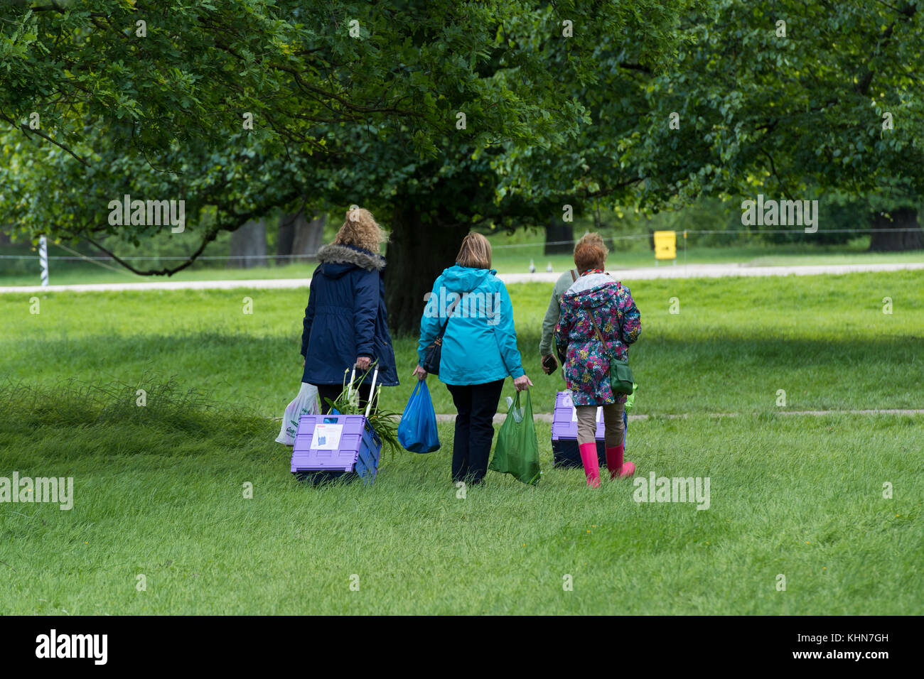 Il tempo per andare a casa per le persone camminare & lasciando showground con borse e piegatura carrelli di shopping - RHS Chatsworth Flower Show, Derbyshire, Inghilterra, Regno Unito. Foto Stock