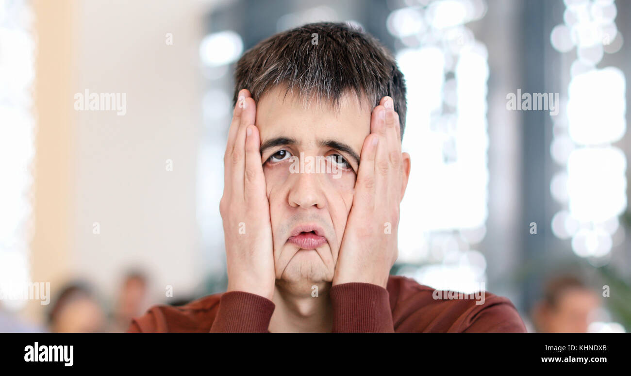 Esaurito l'uomo con le mani sul viso Foto Stock