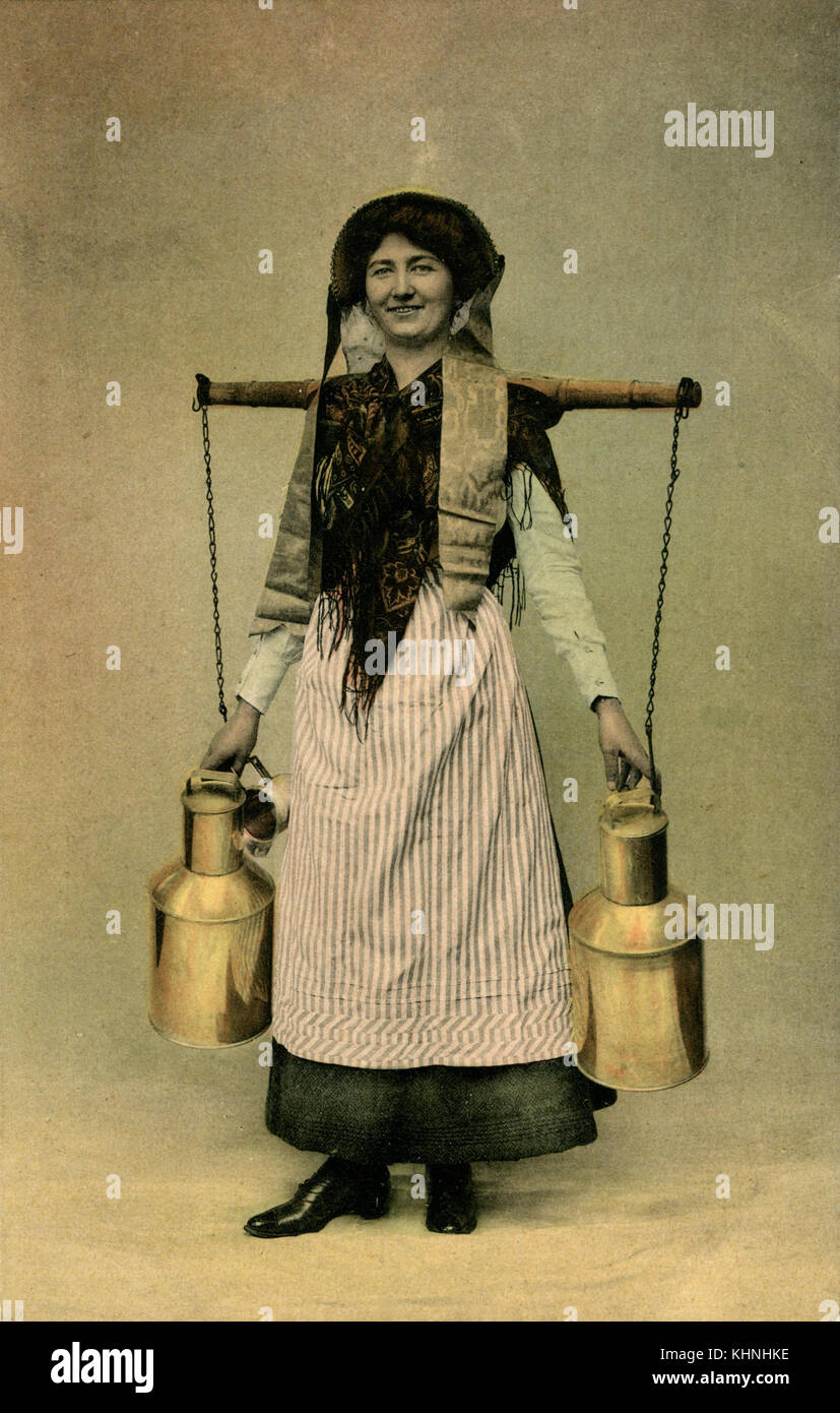 Milkmaid che trasportava due caraffe di latte con l'aiuto di un giogo, nel 1910 (Milchmädchen trägt zwei Milchkannen mit Hilfe eines Jochs, um 1910) Foto Stock