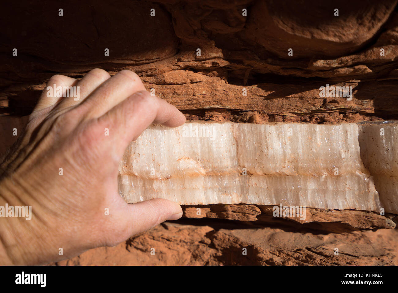 La mano che mostra lo spessore del gesso strato minerale nel Red Rock Canyon caprock texas usa Foto Stock