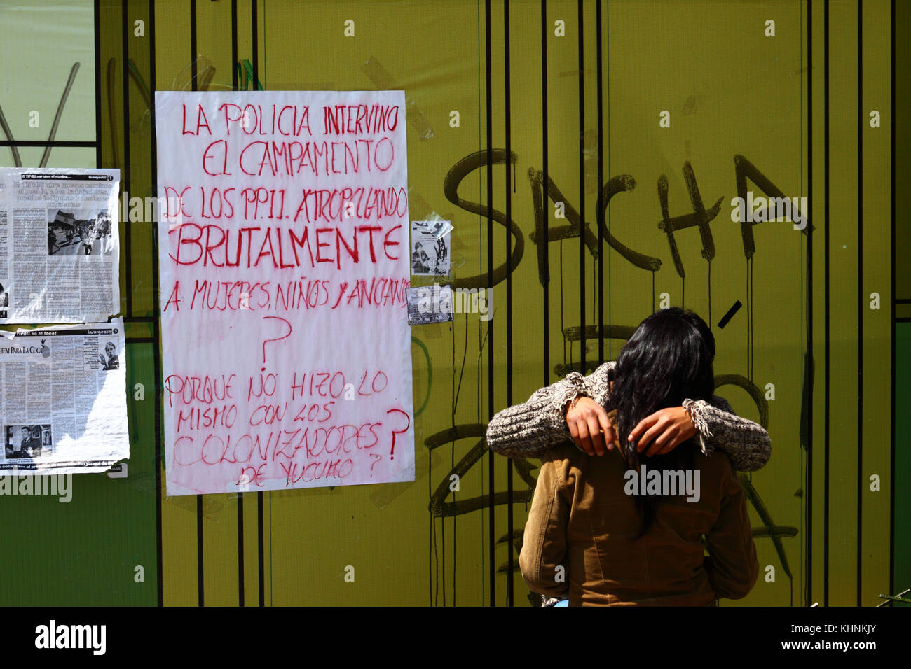 Giovane kissing accanto a un poster che chiedono il motivo per cui la polizia boliviana violentemente invaso la strada TIPNIS marcia di protesta camp a Chaparina vicino a Yucumo, Bolivia Foto Stock