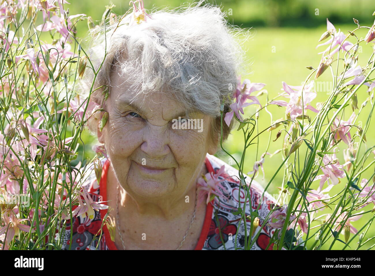 Ritratto di vecchia donna sorridente nel parco Foto Stock