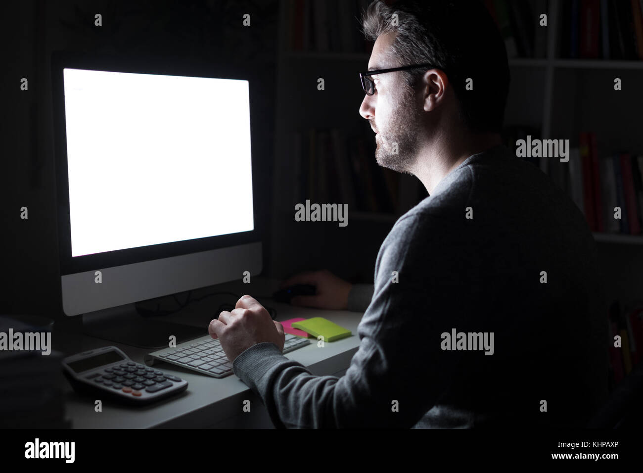 Volto dell'uomo illuminato dalla luce del monitor del computer di notte  Foto stock - Alamy