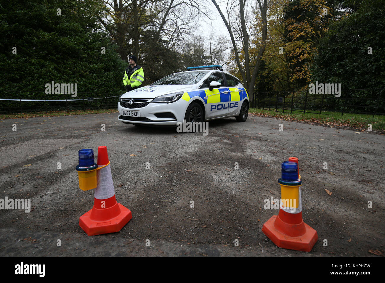 Un uomo di polizia si trova in piedi guardia all'ingresso di Waddesdon Manor Road, nel Buckinghamshire, come la polizia riprendere la caccia per indizi a seguito di una collisione tra un elicottero e un aereo che ha ucciso due piloti e due passeggeri. Foto Stock