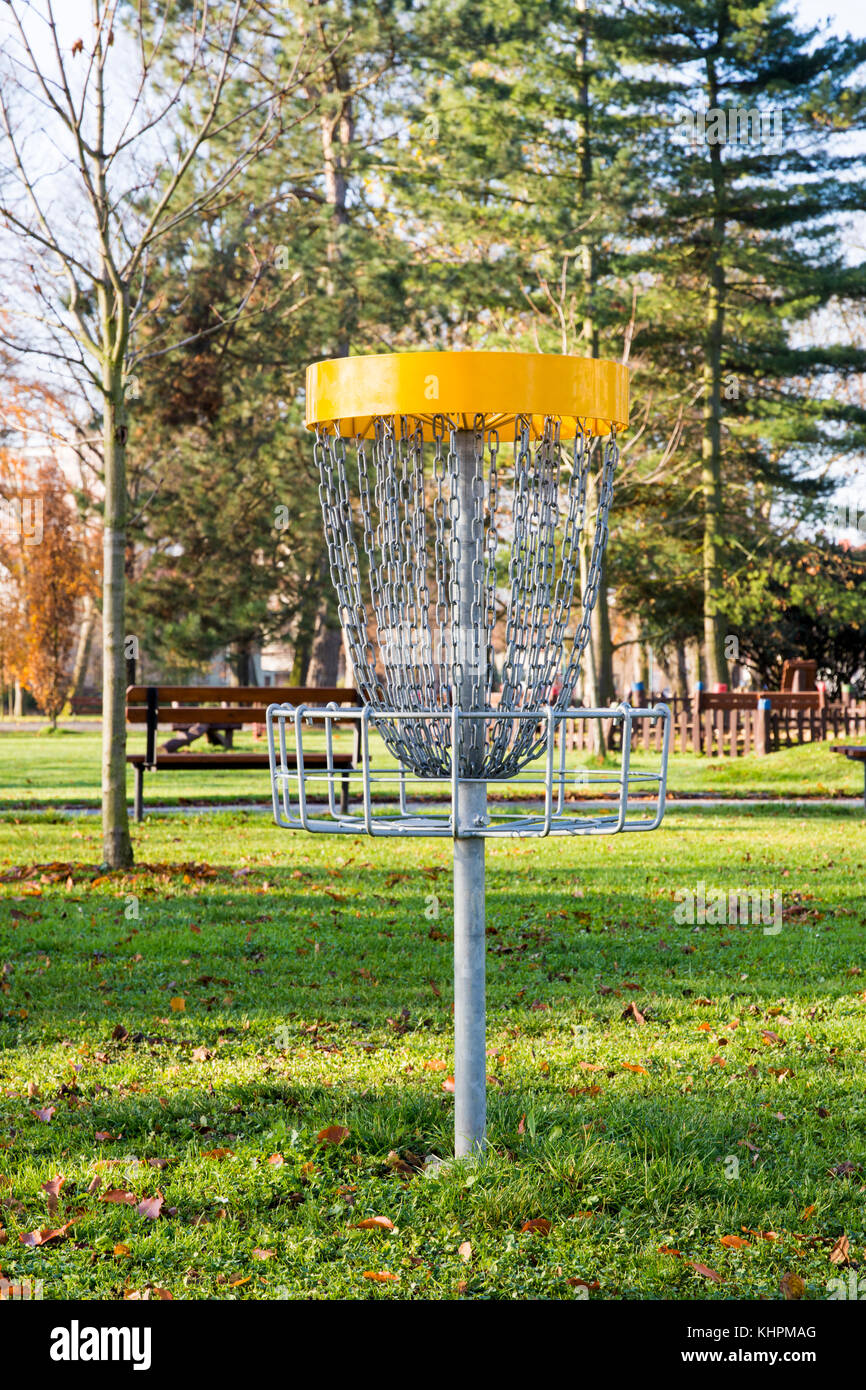 Giocando a basket con catene per gettare i dischi volanti nel parco con alberi secolari e di erba Foto Stock