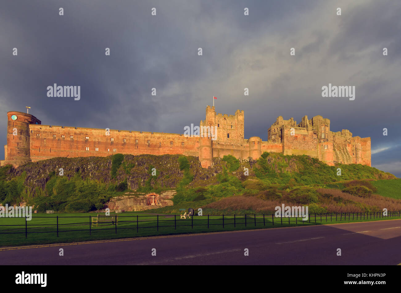 Il castello di Bamburgh nella luce del pomeriggio visto dalla strada principale che attraversa la città. Foto Stock