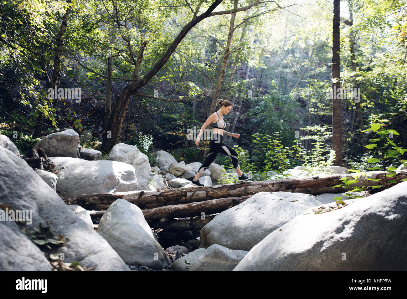 Atleta femminile in esecuzione e fare yoga in foresta Foto Stock