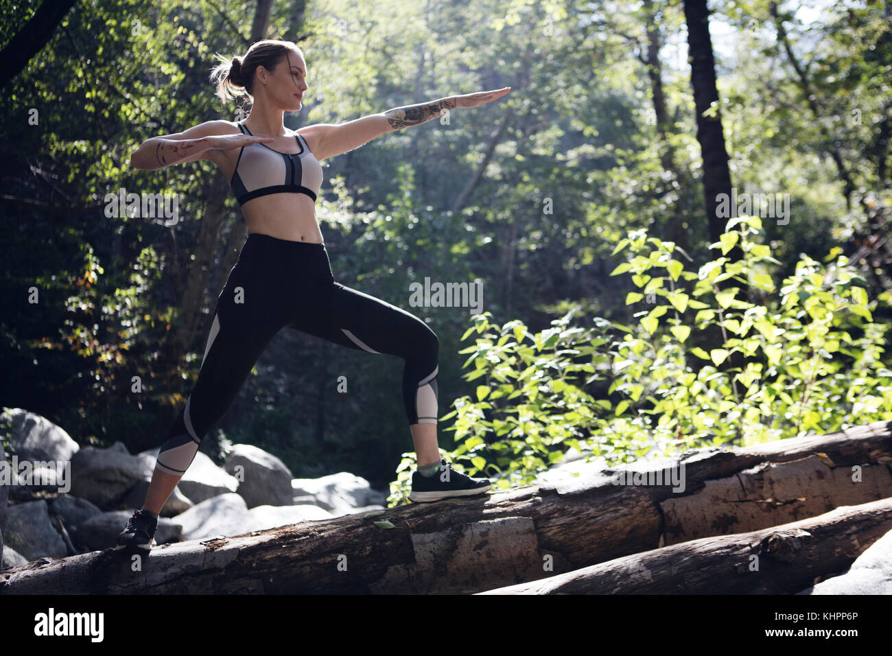 Atleta femminile in esecuzione e fare yoga in foresta Foto Stock