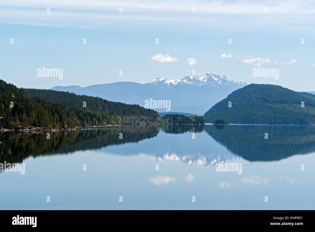 Montagne innevate della riflessione in un lago - isola di Vancouver, BC, Canada Foto Stock