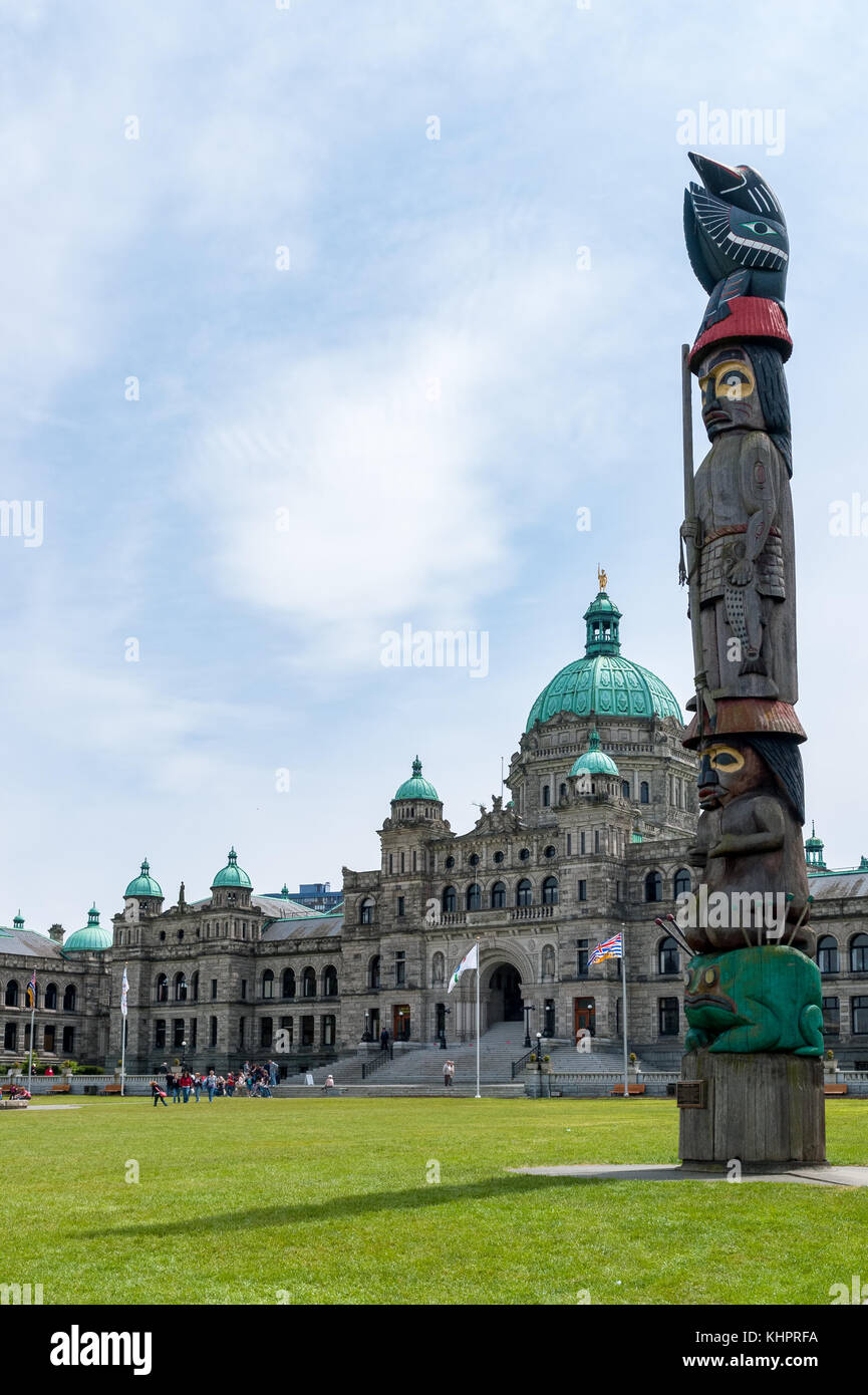 Il totem pole con British Columbia il Parlamento in background - Victoria, Canada. Foto Stock