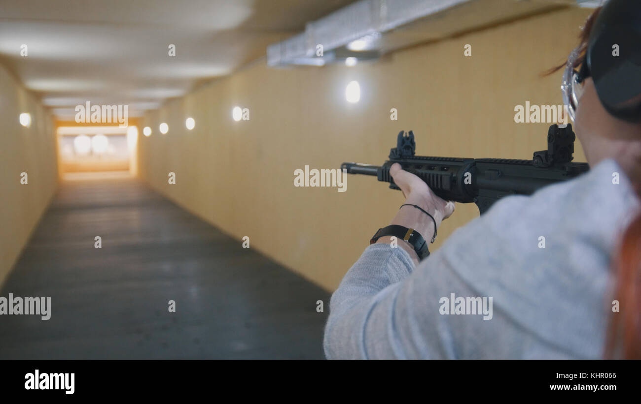 Donna tiro con un machinegun ha in galleria di tiro Foto Stock