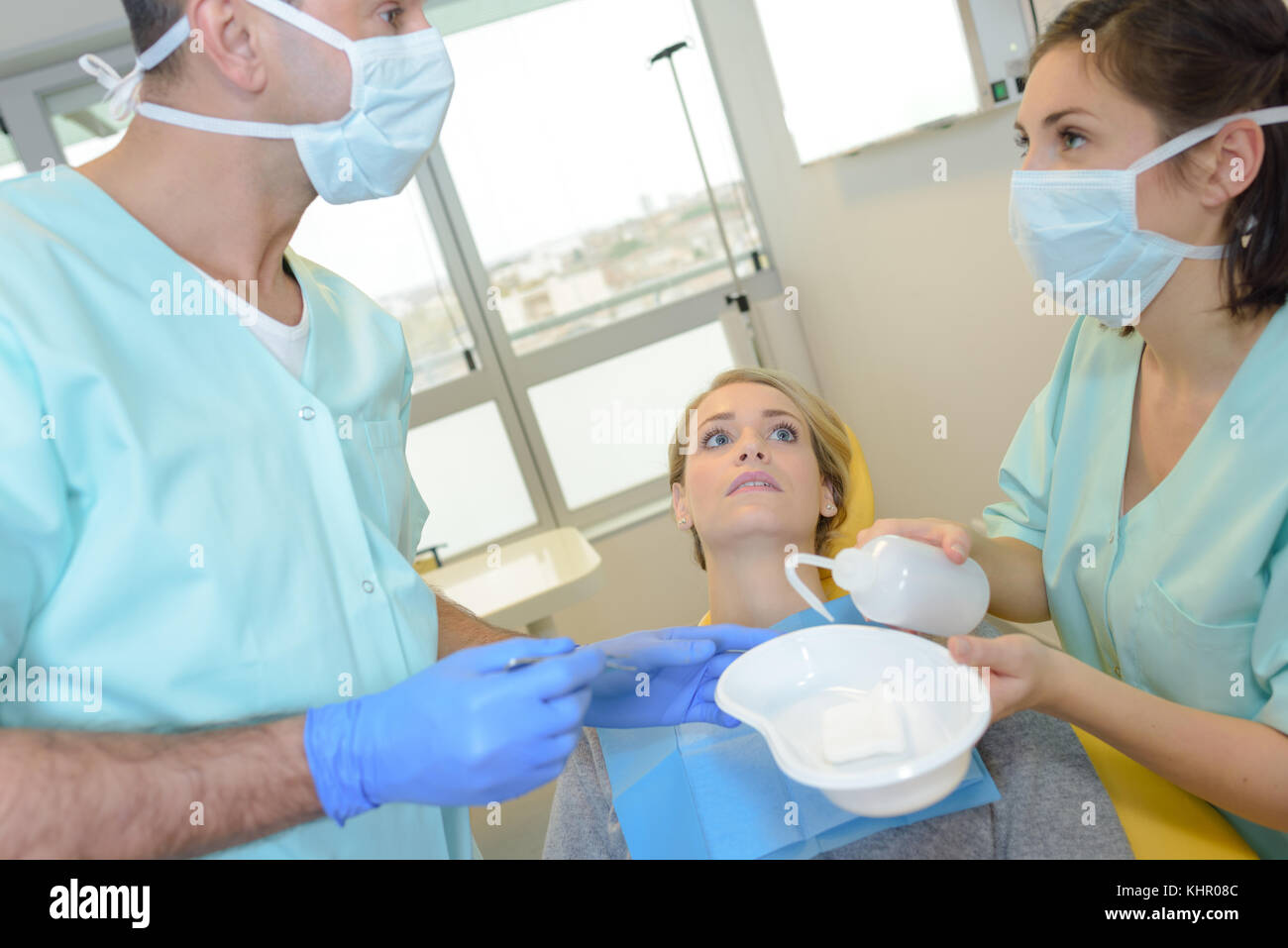 Dentista e assistente di parlare, cerca paziente ansioso Foto Stock