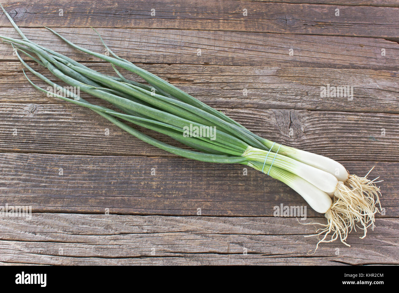 Giovani cipolla su sfondo di legno Foto Stock