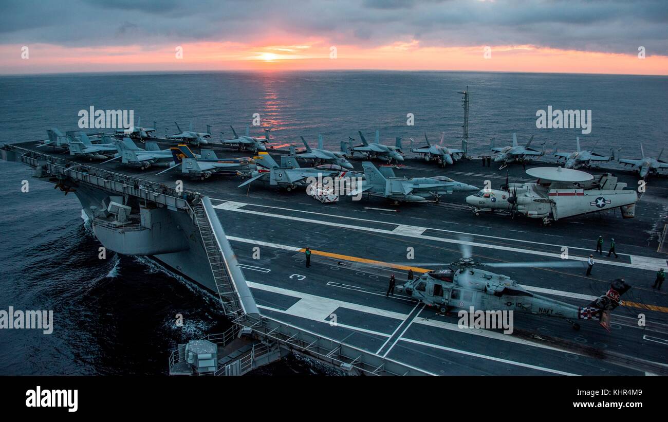 Un U.S. NAVY MH-60s seahawk elicottero decolla da il ponte di volo della marina degli Stati Uniti nimitz-class portaerei USS carl vinson al tramonto novembre 12, 2017 nell'oceano pacifico. (Foto di Sean m. castellano via planetpix) Foto Stock