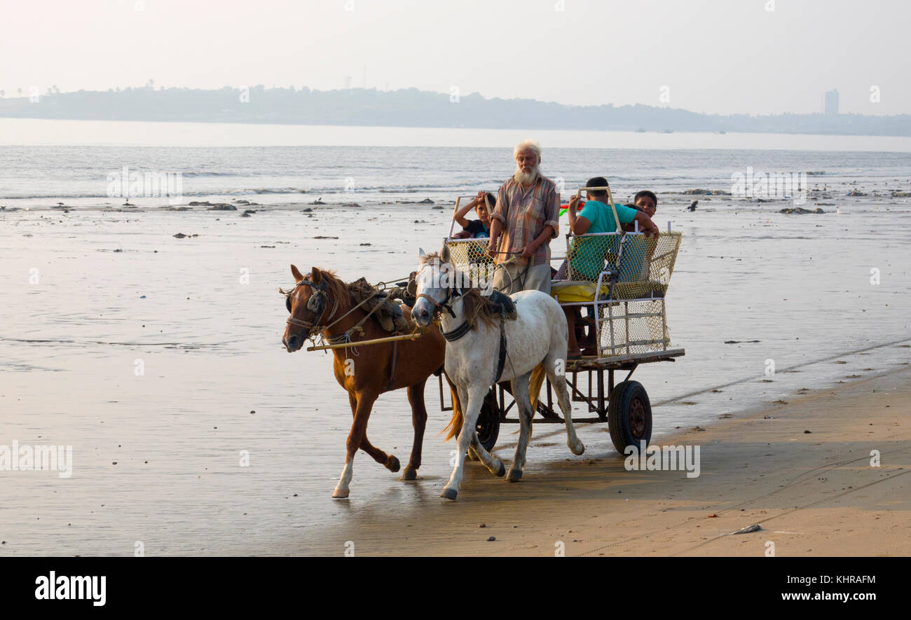 Cavallo e il carrello scorre su una spiaggia Juhu di Mumbai Foto Stock
