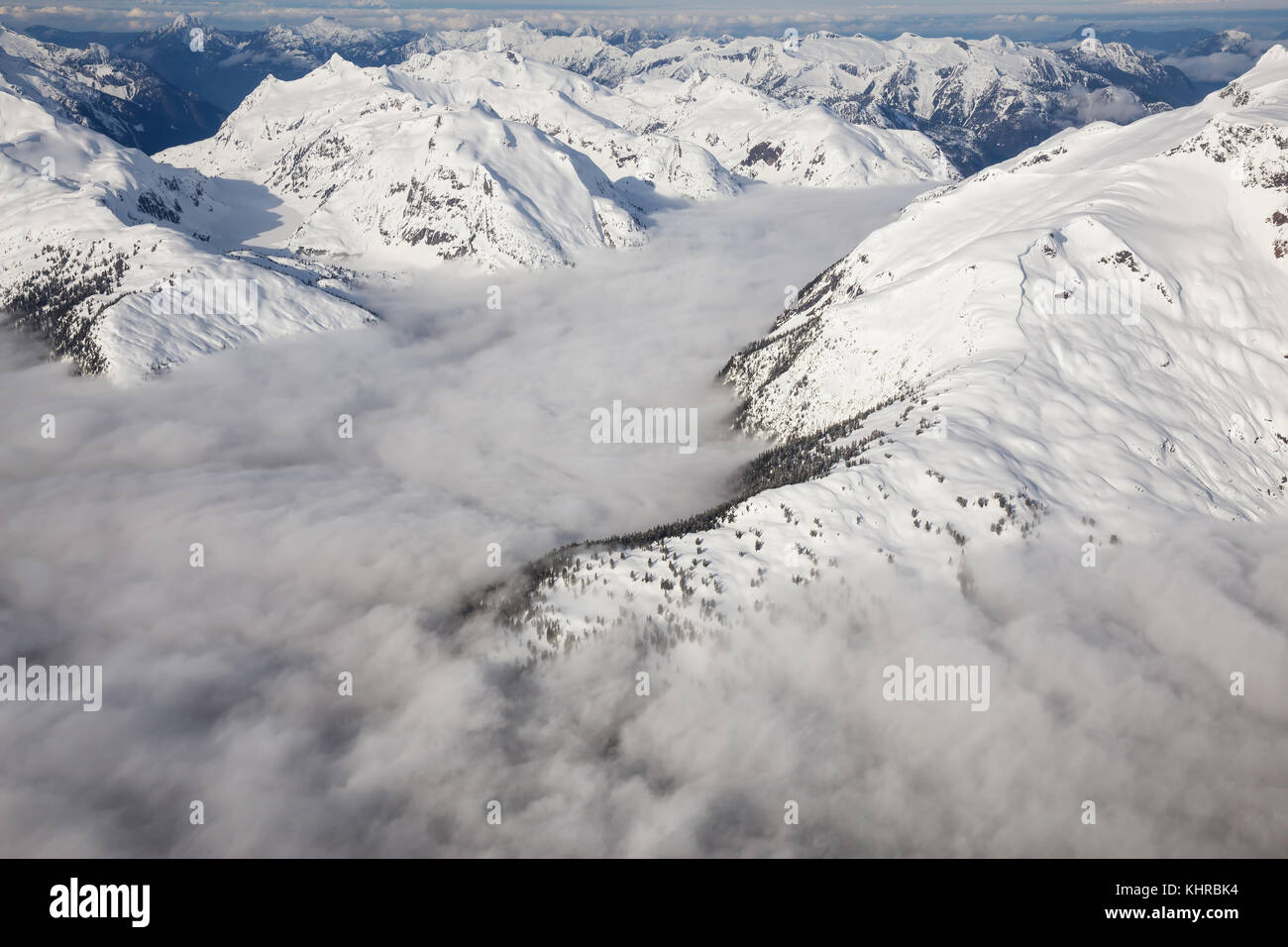 Antenna di bella vista del paesaggio di montagne coperte di neve gamma con un basso livello di cloud. prese nella remota area mattina presto a nord-ovest di vanc Foto Stock
