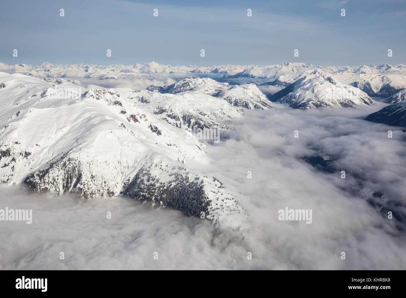 Antenna di bella vista del paesaggio di montagne coperte di neve gamma con un basso livello di cloud. prese nella remota area mattina presto a nord-ovest di vanc Foto Stock