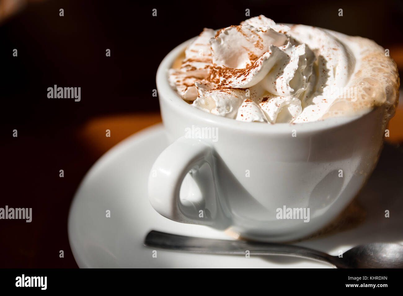 Tazza di cappuccino con panna montata e cannella sulla parte superiore Foto Stock