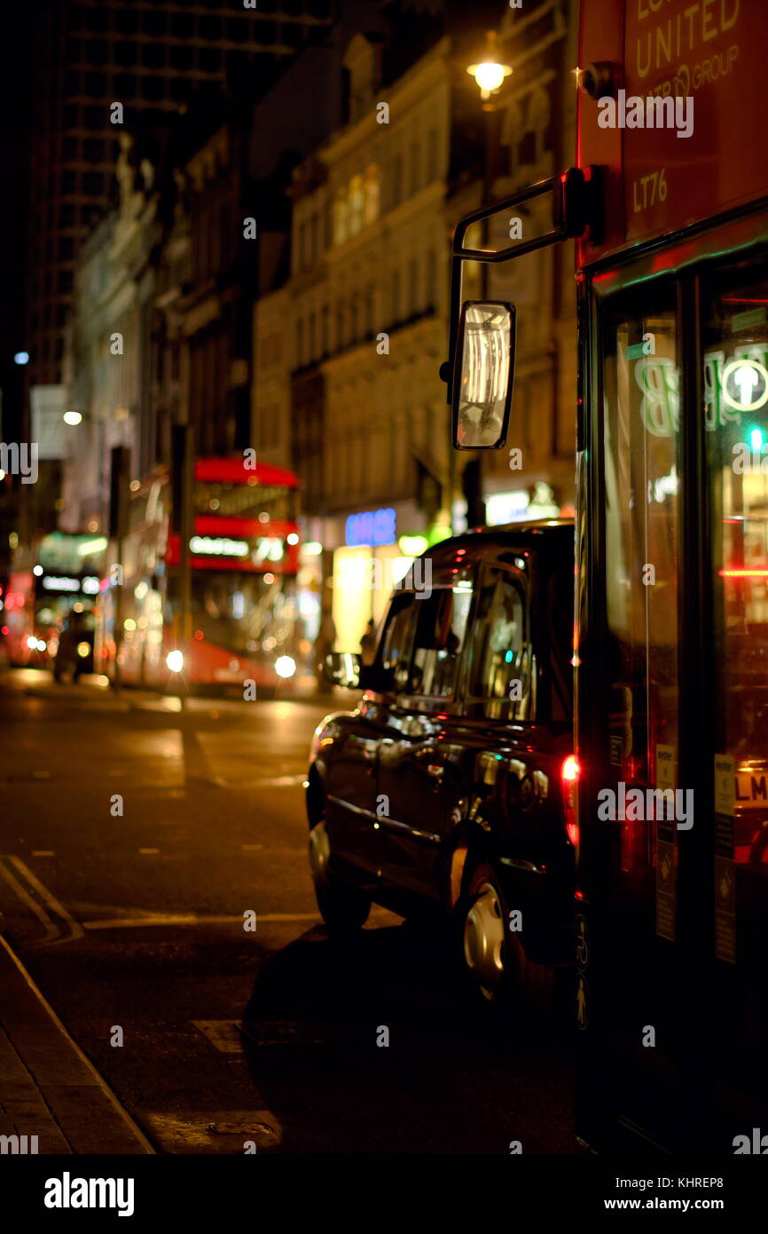 Autobus e taxi in attesa ad un semaforo di notte su Oxford Street, Londra, Inghilterra Foto Stock