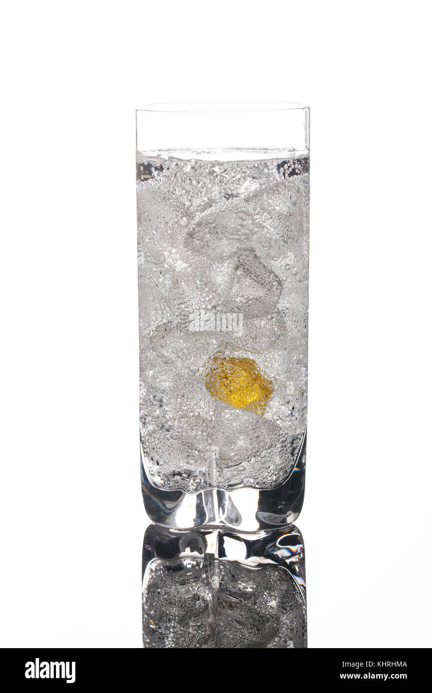 La formazione di cristalli di ghiaccio in un bicchiere con acqua su un sfondo di vetro Foto Stock